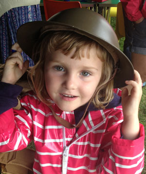 Little girl wearing a soldiers helmet